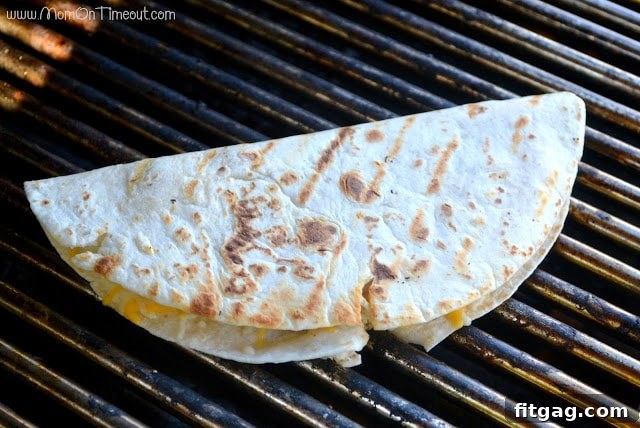 Two halves of a perfectly grilled shrimp quesadilla showing melted cheese and shrimp
