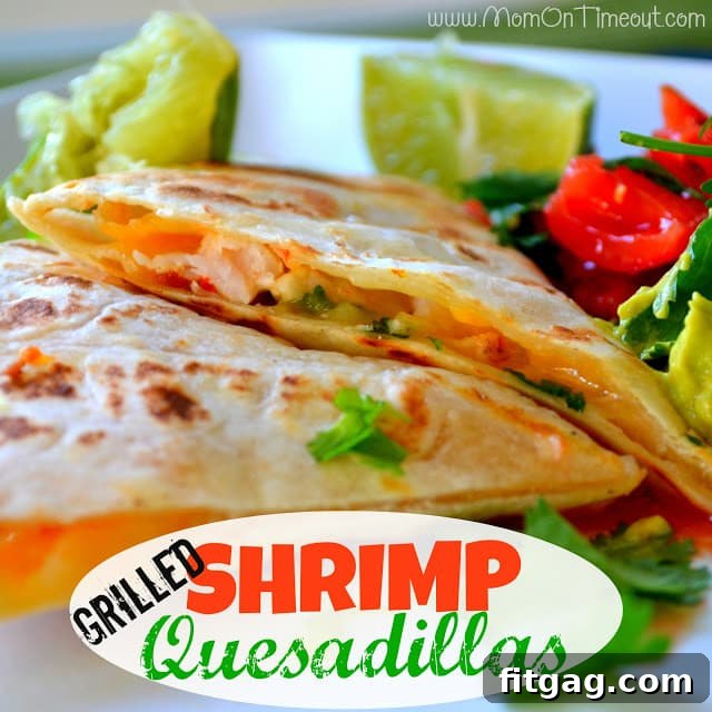 Beautifully arranged platter of grilled shrimp quesadilla wedges garnished with cilantro and lime