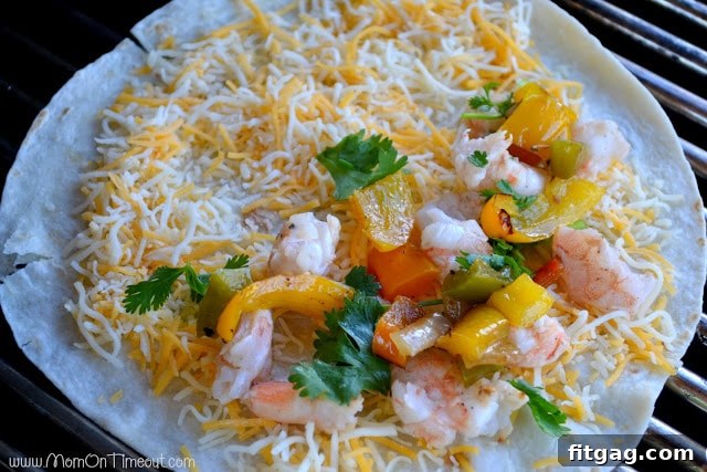 Shrimp, cheese, and cilantro filling being added to one half of a tortilla on the grill