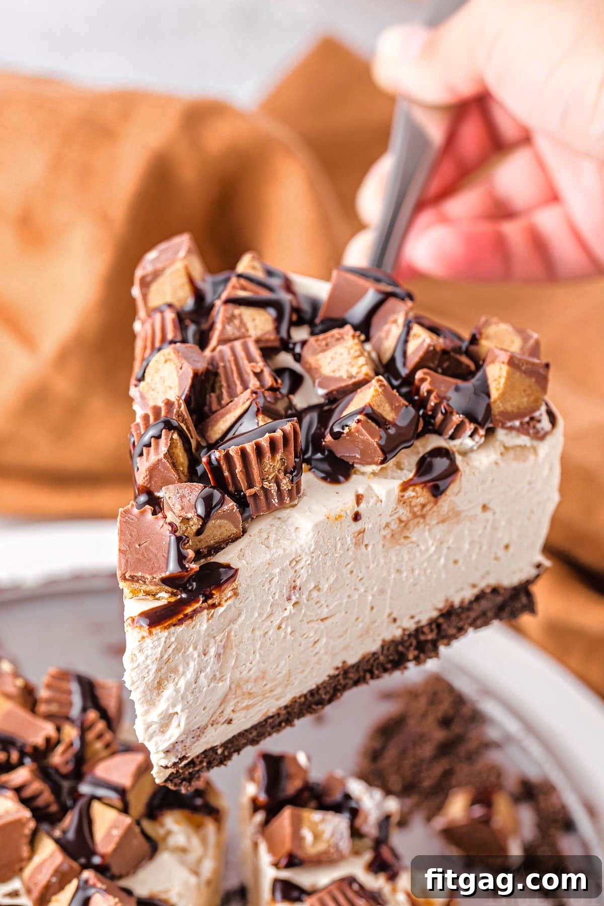 A perfect slice of peanut butter cheesecake being carefully lifted above the cheesecake pan, poised to be placed on a plate and enjoyed. Showcases the creamy texture and defined crust.