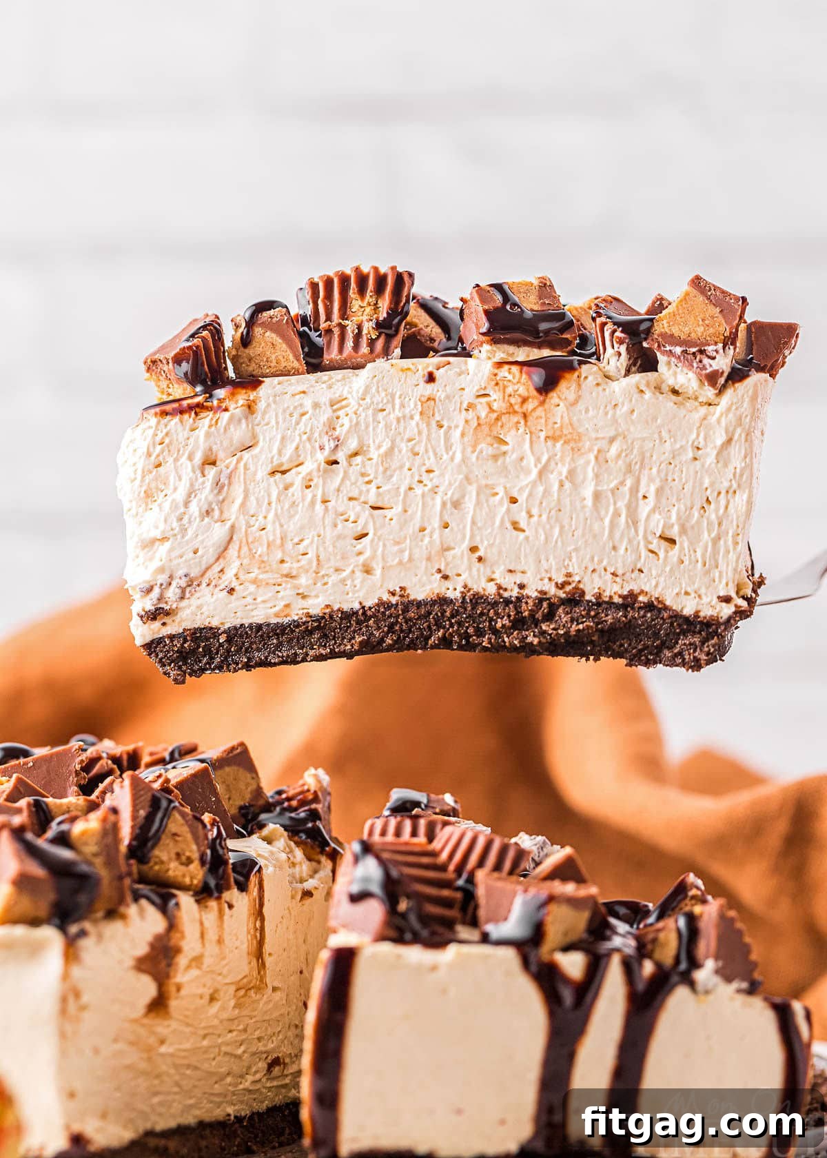 A perfectly portioned slice of cheesecake elegantly held above the remainder of the cheesecake still nestled in its pan, showcasing its smooth texture and rich layers.