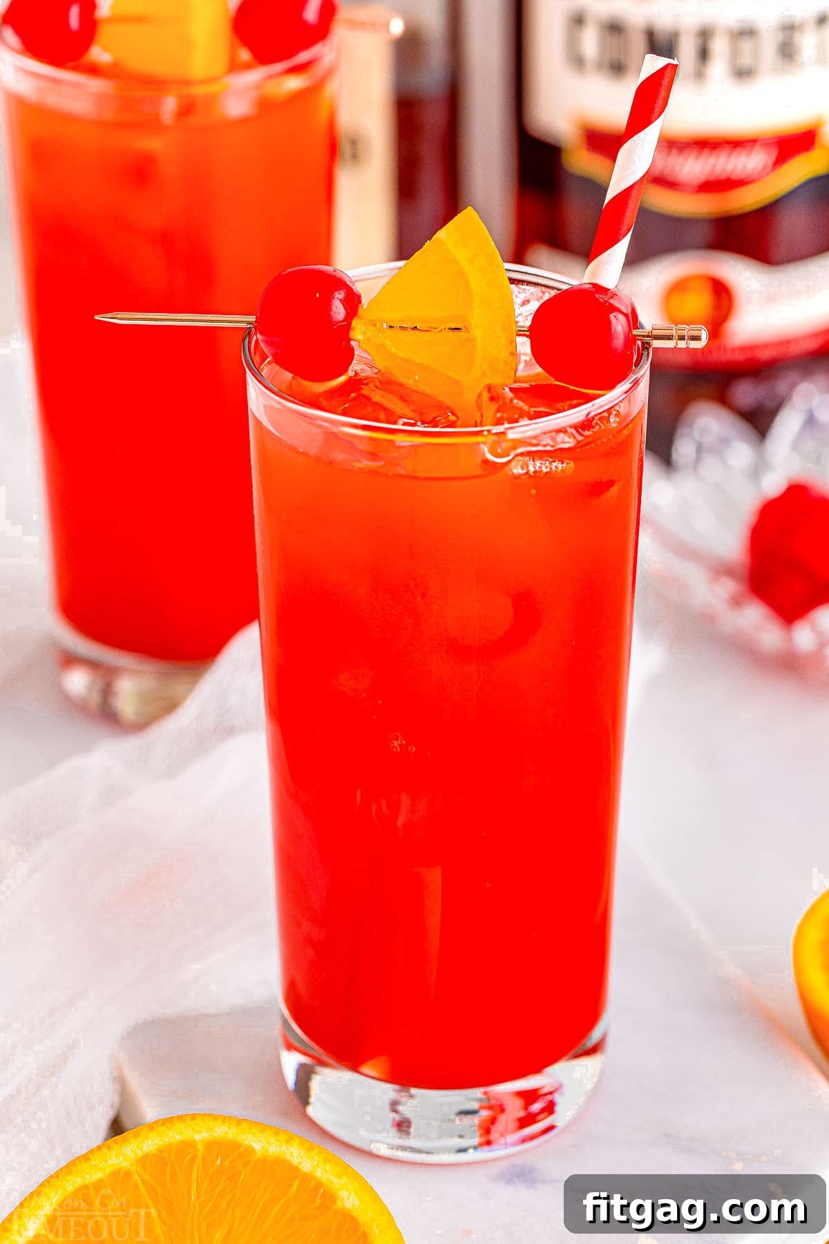 Southern Knockout 3 Two perfectly poured Alabama Slammer drinks, garnished and ready to be enjoyed in elegant tall glasses.