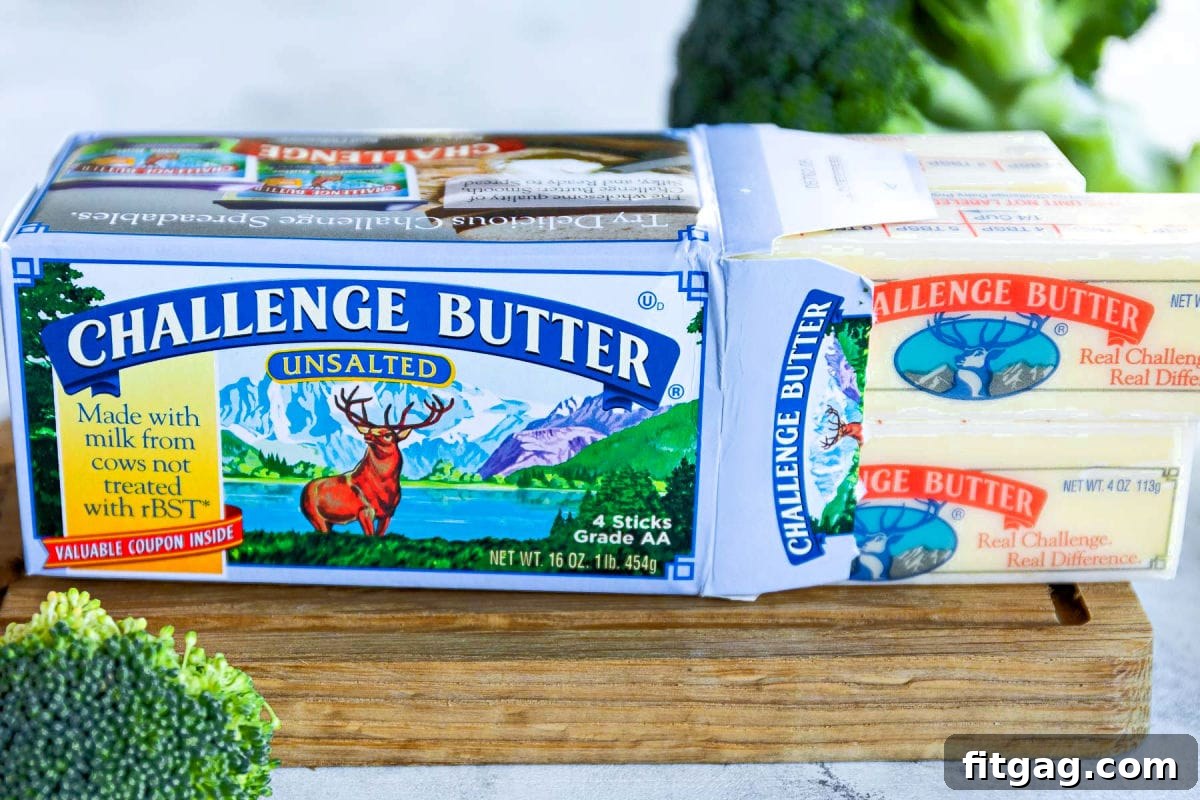 box of challenge unsalted butter on small cutting board with butter sticks pulled out of the side of the box.