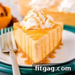 A beautiful slice of No Bake Pumpkin Cheesecake topped with whipped cream and caramel drizzle.