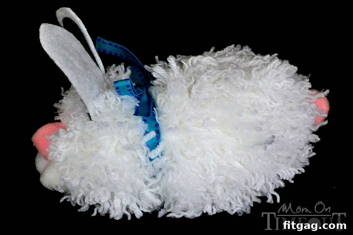 Fluffy Easter Bunny Craft 7 Side view of a finished pom pom bunny, showing the placement of its fluffy tail and a decorative ribbon.