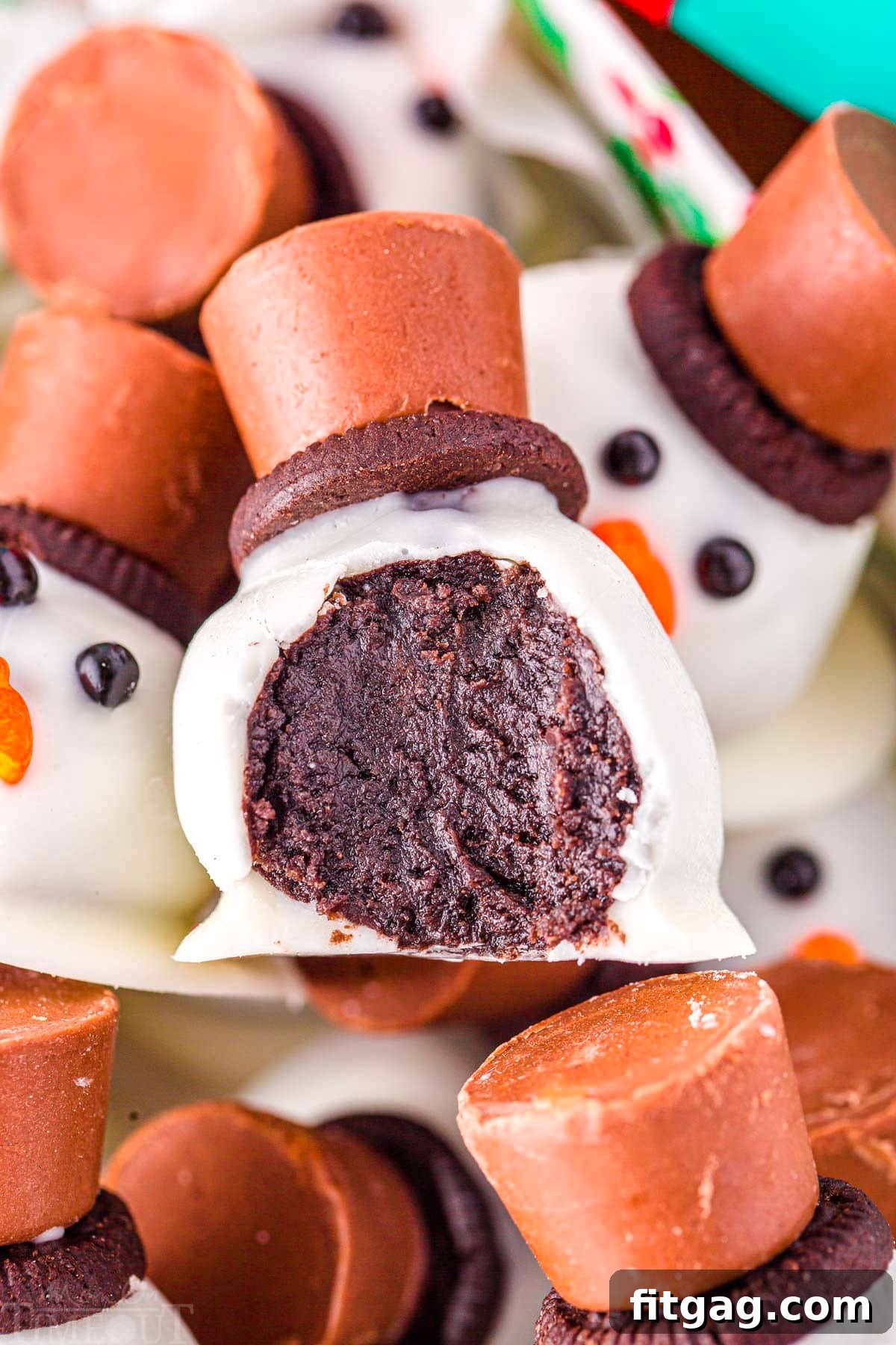 Disappearing Snowman Oreo Truffles 3 snowman oreo ball with a bite taken out of it in a box with more melting snowman.