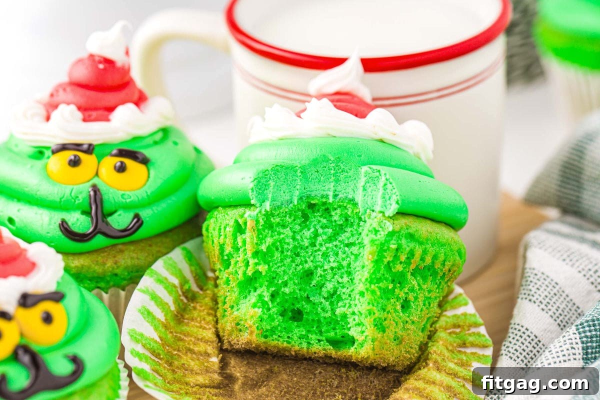 green cupcakes with green frosting decorated to look like the grin with the main cupcake with a bit taken out of it.