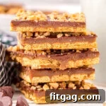 Six pieces of graham cracker toffee stacked on top of each other with some chocolate chips scattered in front.