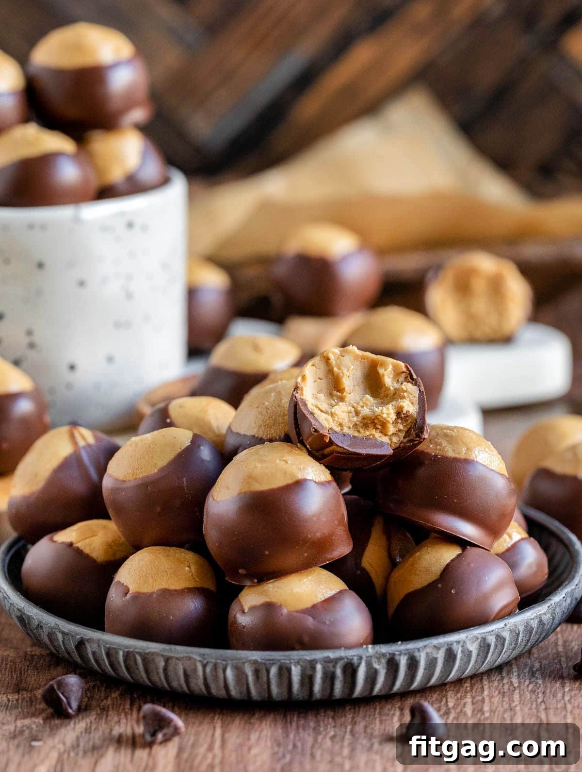 Ohio's Buckeye Story 9 An inviting arrangement of buckeyes on a silver plate, with one candy revealing a tempting bite. More buckeyes are elegantly presented in a white mug, and additional candies are scattered artfully around the display.