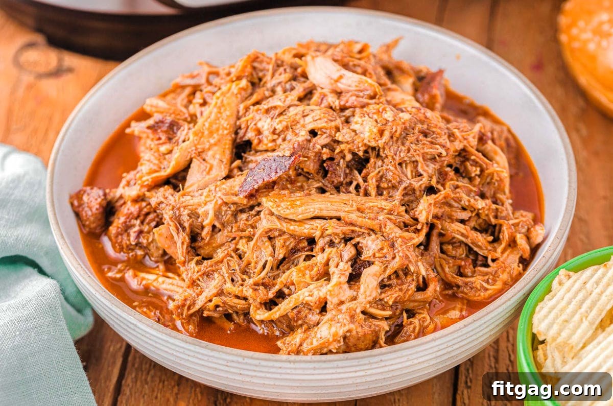 Effortless Instant Pot Pulled Pork 5 A large bowl generously filled with perfectly shredded pulled pork, ready to be served.