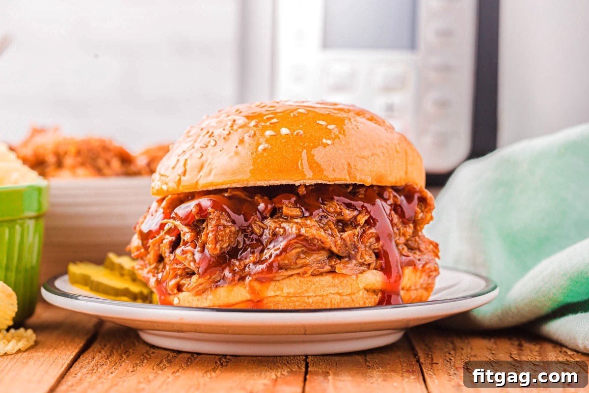 A classic Instant Pot pulled pork sandwich, perfectly assembled on a plate, with the Instant Pot standing by, ready for another delicious meal.