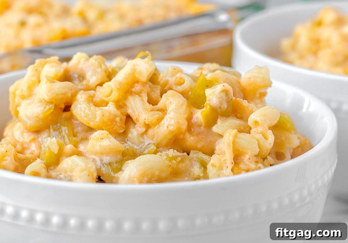 close up look at green chile mac and cheese in a white bowl.