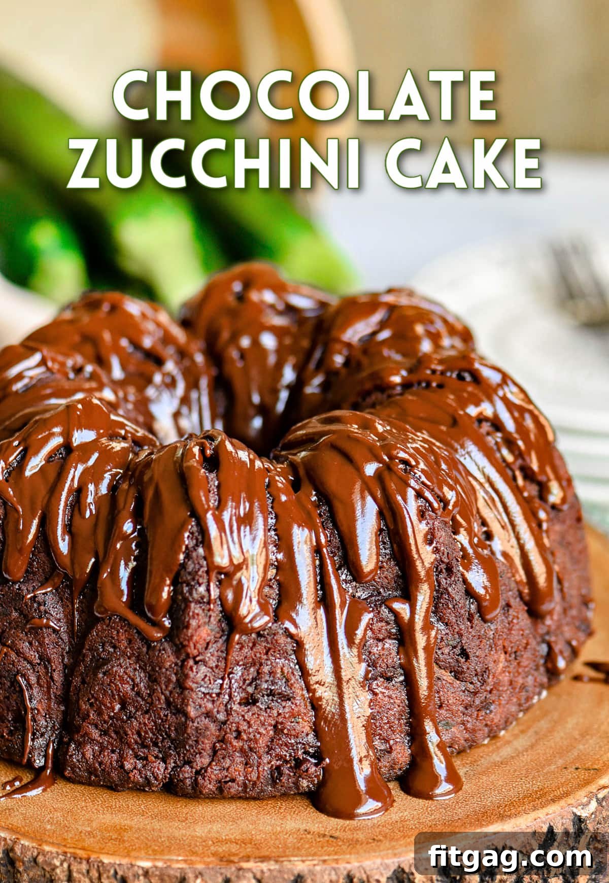 Decadent Chocolate Zucchini Cake 2 whole chocolate zucchini bundt cake on wood cake stand with rich chocolate glaze on top of cake.