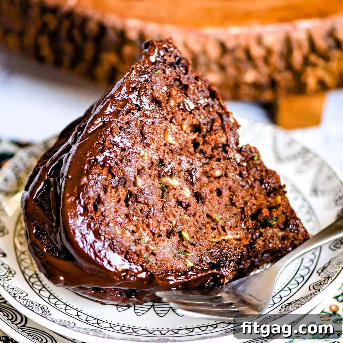Decadent Chocolate Zucchini Cake 4 slice of chocolate zucchini cake on white plate.