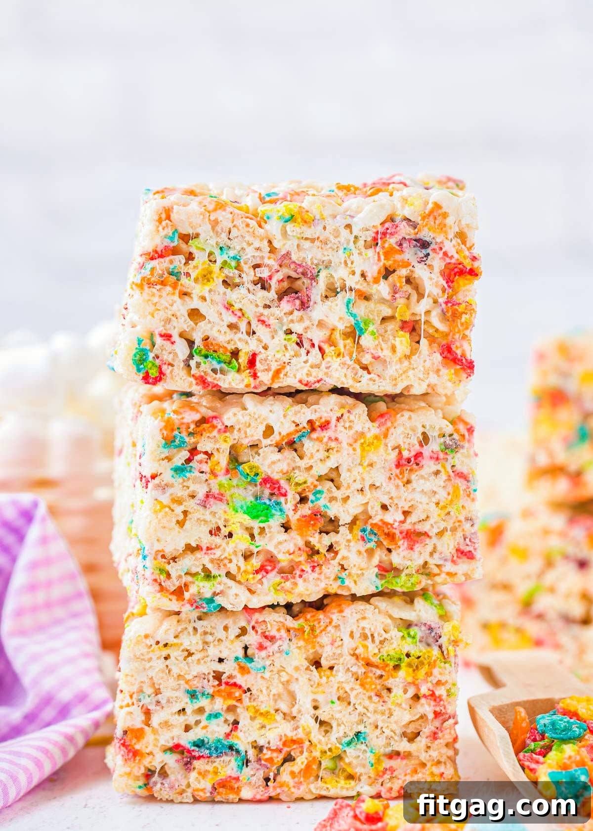 Vibrant Rainbow Krispie Bars 3 Three perfectly stacked Rainbow Rice Krispie Treats, made with colorful Fruity Pebbles cereal, ready to be enjoyed.
