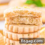 Zesty Lemon Basil Shortbread 7 lemon shortbread cookies stacked about 10 high with the top cookie broken in half.