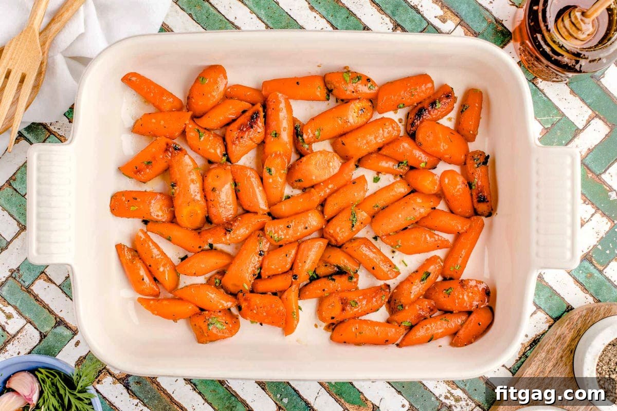 Honey Kissed Carrots 5 Top-down view of honey roasted carrots in a white baking dish.