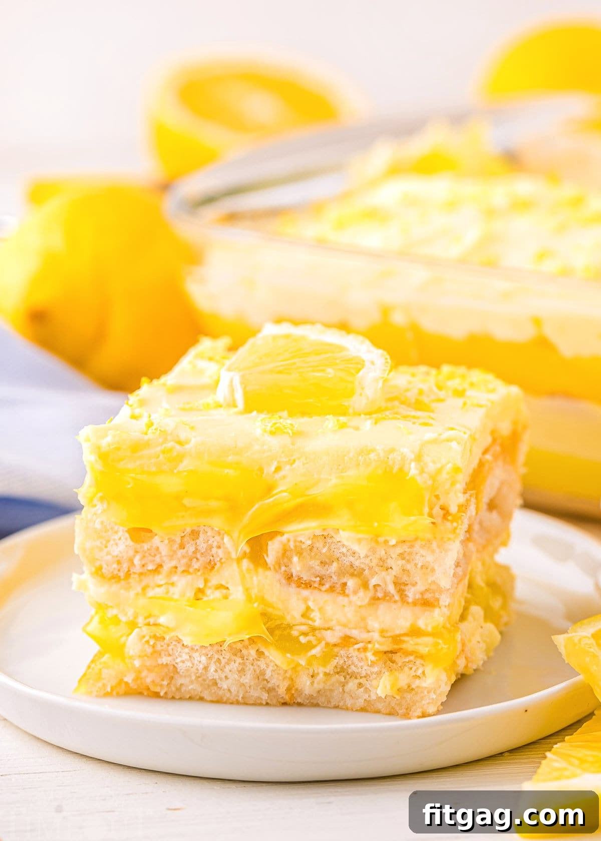 A perfectly layered slice of Lemon Tiramisu, showcasing its creamy and bright yellow layers, served on a white dessert plate.