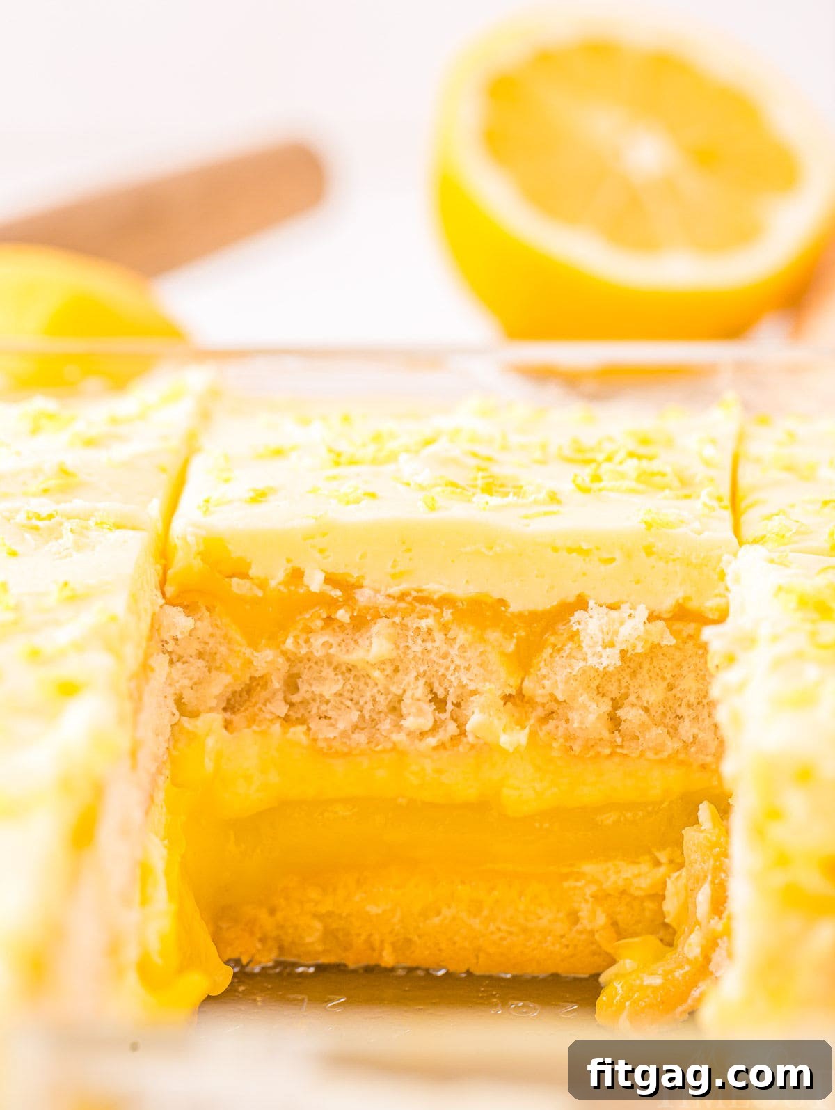 A shot of the complete Lemon Tiramisu in a clear baking dish, with one serving removed, revealing the perfect layers of the dessert.