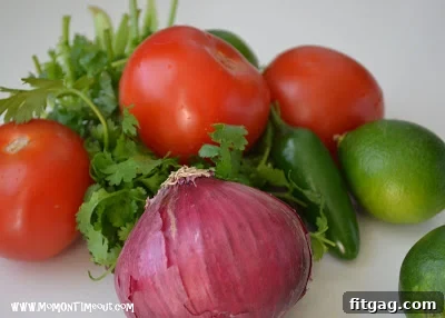 Close-up of fresh, diced ingredients for Pico de Gallo, including tomatoes, cilantro, and red onion.