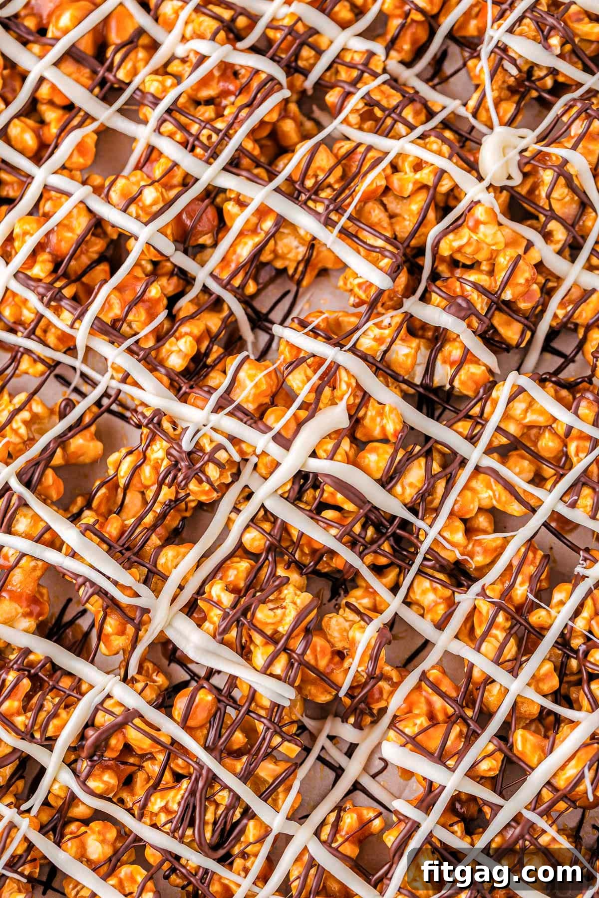 Zebra Swirl Popcorn 6 A mesmerizing top-down, close-up perspective of the finished Zebra Popcorn recipe, beautifully highlighting the artistic dark and white chocolate drizzles atop the golden caramel corn.