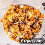 A delicious bowl of Zebra Popcorn, featuring homemade caramel corn elegantly drizzled with dark and white chocolate stripes.