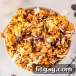 Zebra Swirl Popcorn 7 top down look at caramel corn in white bowl on marble surface. popcorn has been drizzled with white and dark chocolate.