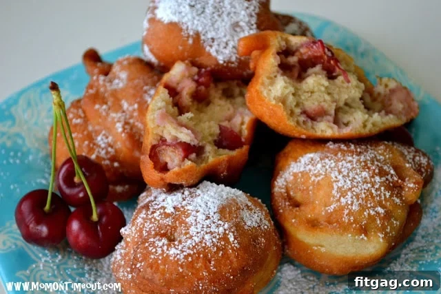 A close-up shot of the interior of a cherry fritter, showing juicy cherry chunks