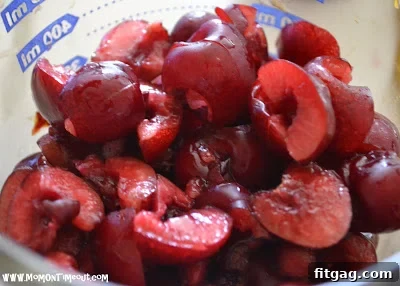 Fritter batter with cherries being dropped into hot oil for frying