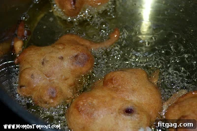 Freshly fried cherry fritters draining on paper towels