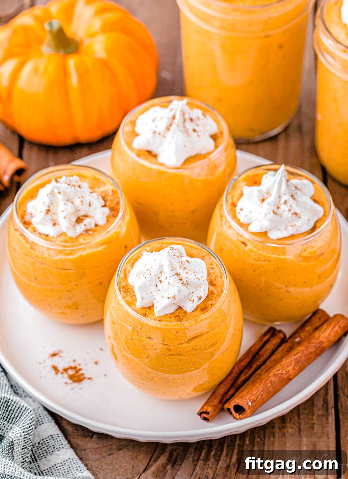 Creamy Pumpkin Cloud 5 top down angled view of four glasses filled with pumpkin mousse topped with whipped cream.