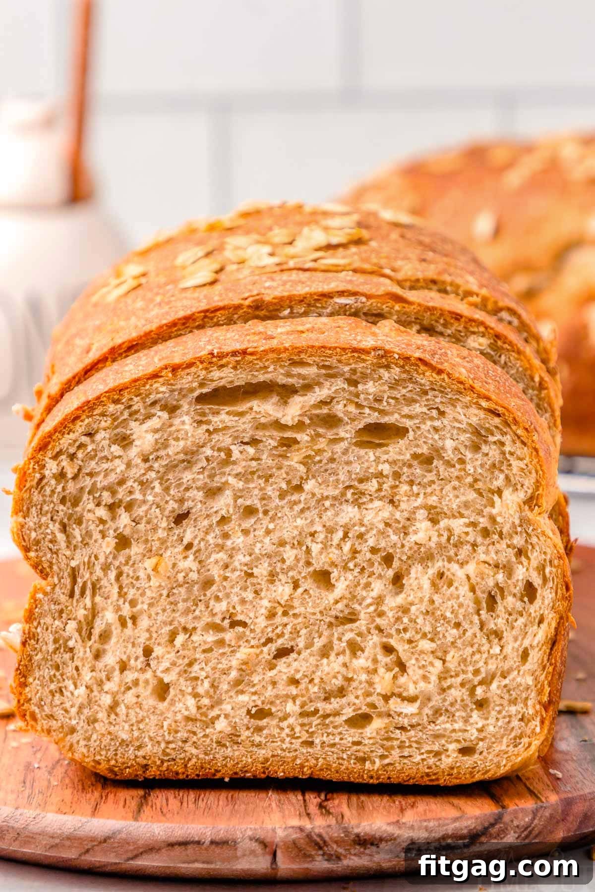 Wholesome Wheat Loaf 2 A freshly baked loaf of golden-brown whole wheat bread on a rustic wooden board, with a slice cut off, revealing its fluffy interior. Perfect for sandwiches, soups, and toast.