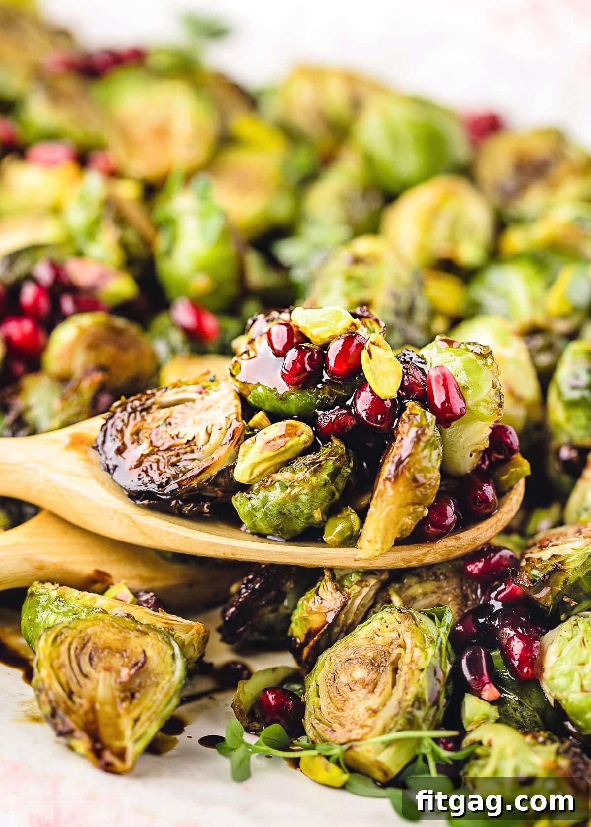 Caramelized Roasted Brussels Sprouts 7 wooden spoon with roasted brussels sprouts sitting on more sprouts.