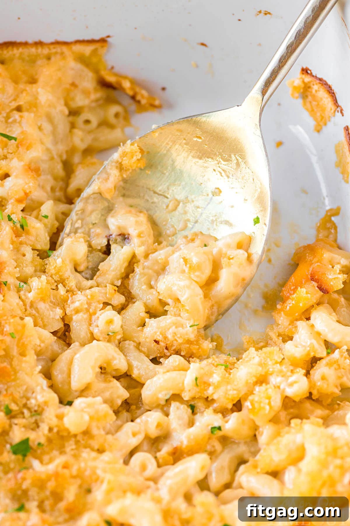 Liquid Gold Mac 5 top down view of casserole dish with a serving or two of mac and cheese with velveeta removed from the oven.