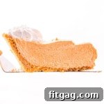 Effortless Pumpkin Pie 7 slice of no bake pumpkin pie held above pie plate.