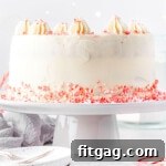 Frosted Peppermint Indulgence 8 A whole Peppermint Cake on a white cake stand, surrounded by scattered candy cane crumbles, ready for a festive celebration.