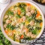 top down view of bowl of italian wedding soup topped with freshly grated parmesan cheese. the pot of soup is next to it.