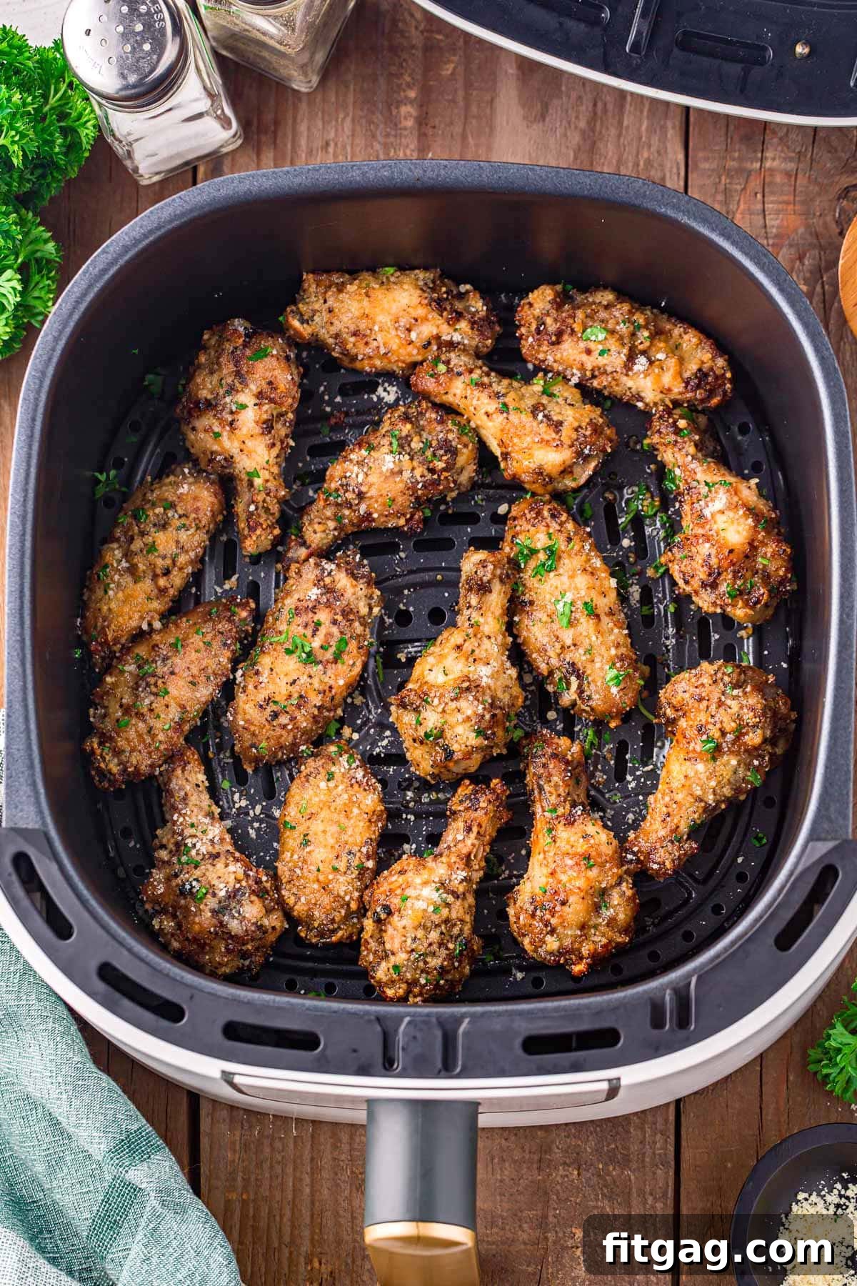 Crispy Garlic Parmesan Wings 3 Crispy garlic parmesan wings perfectly cooked and arranged in an air fryer basket, ready to be enjoyed.