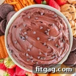 Fudgy Brownie Dip 7 Close up top down shot of a bowl of brownie batter dip surrounded by dippers including fresh strawberries, nilla wafers, pretzels and cookies.