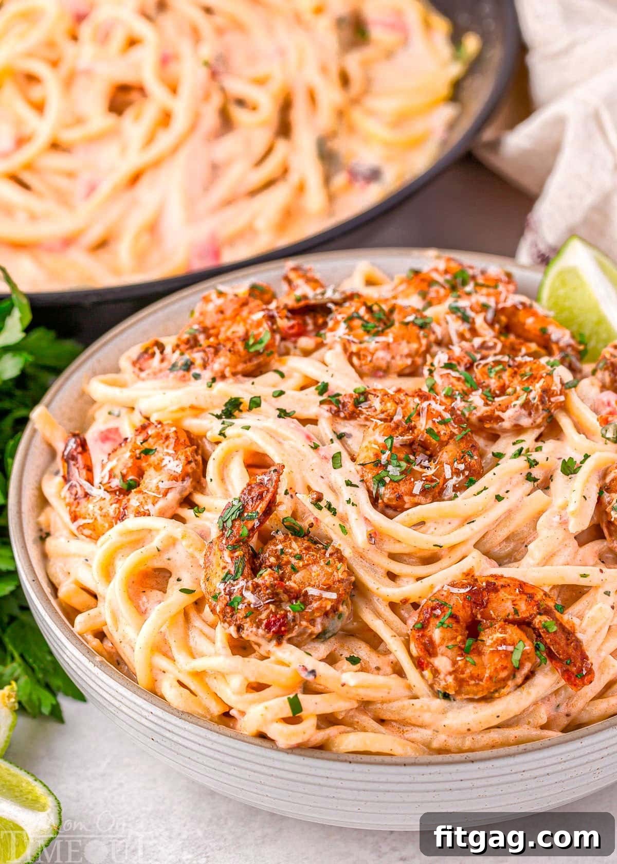 A close-up view of a bowl of creamy Cajun Shrimp Pasta, showcasing perfectly cooked shrimp coated in a rich Parmesan cream sauce, garnished with fresh herbs.