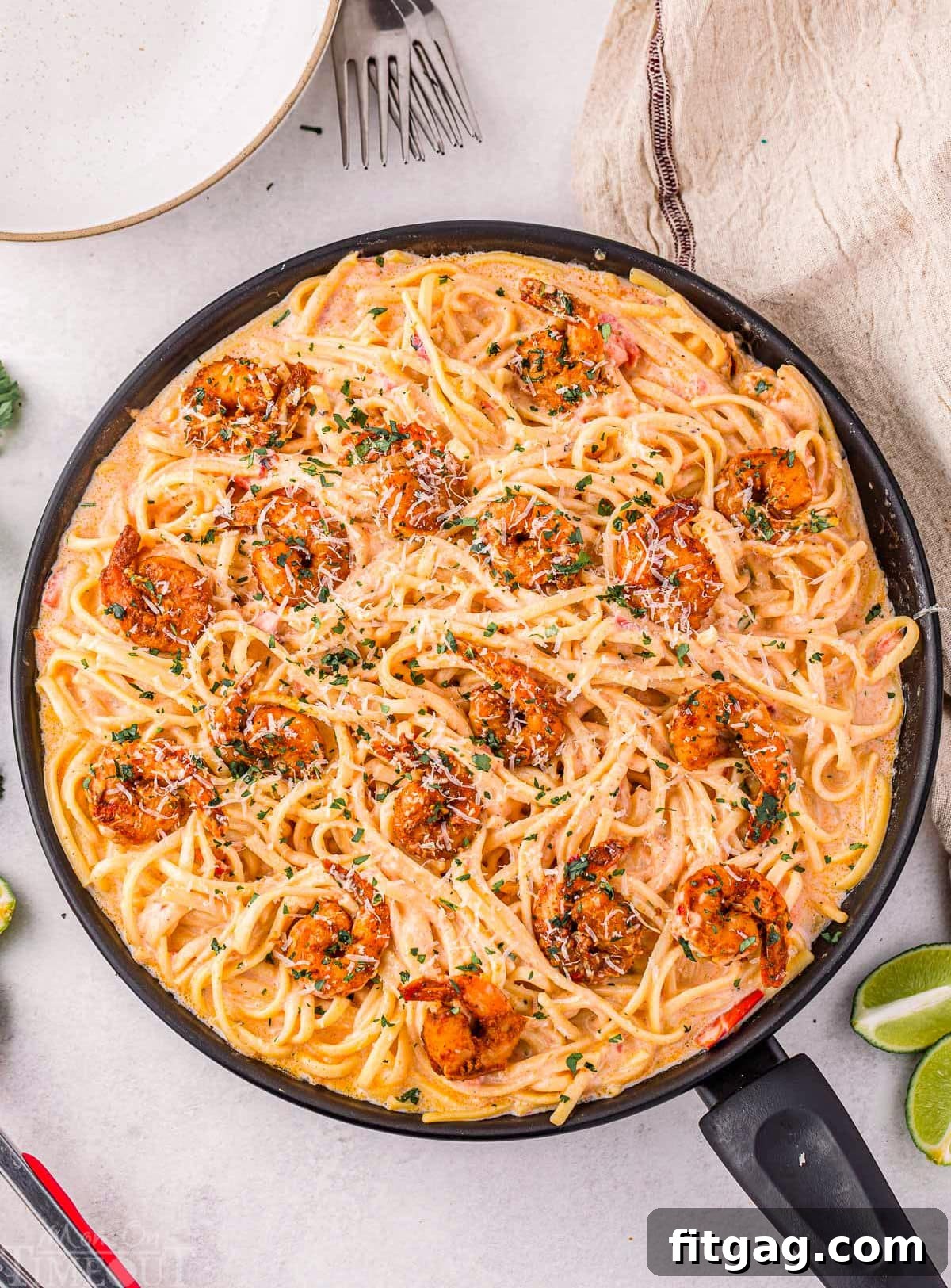 An overhead shot of a skillet filled with freshly made Cajun Shrimp Pasta, beautifully garnished and ready to be served family-style.