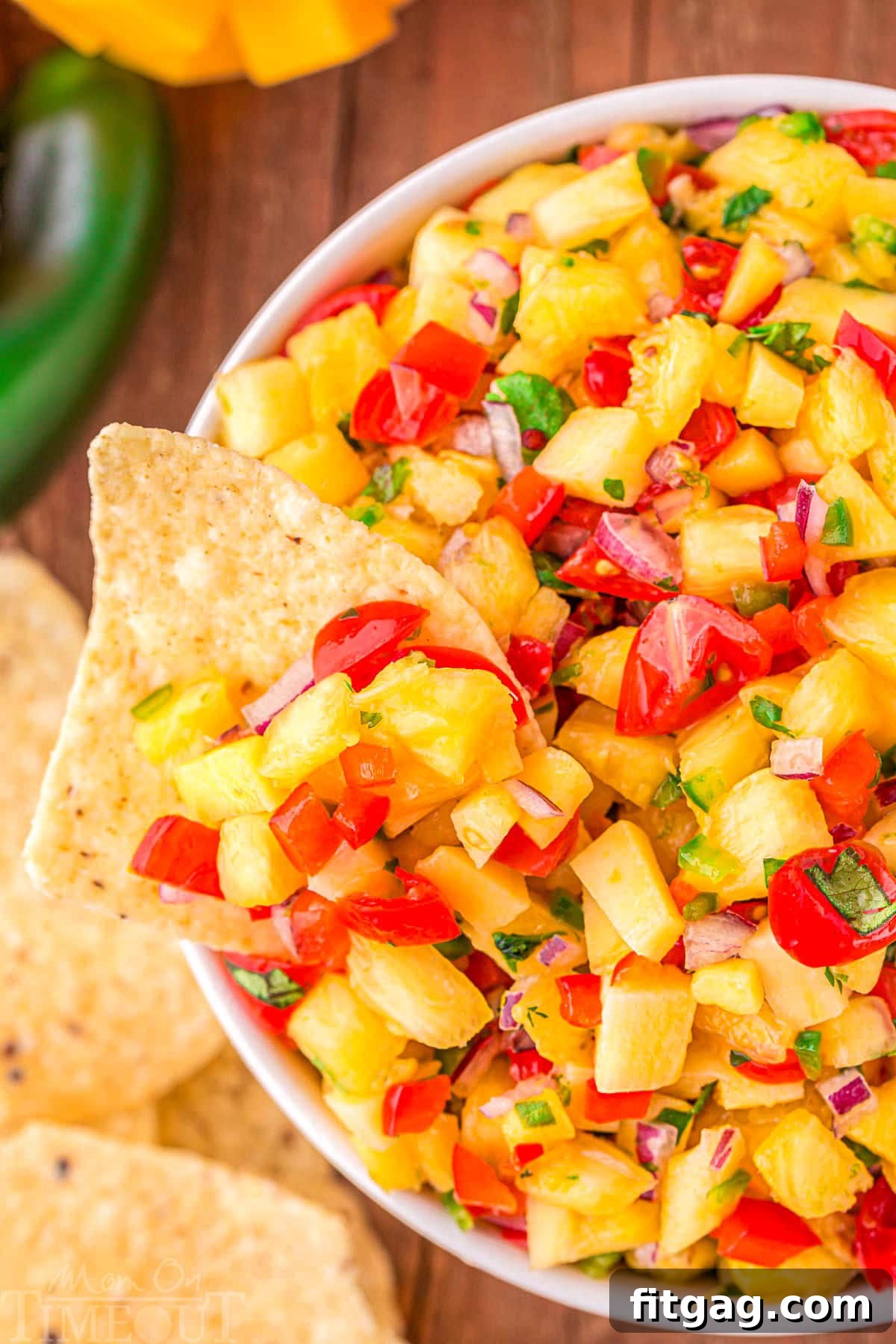 Tropical Pineapple Mango Salsa 3 bowl of pineapple mango salsa with a chip dipped into the bowl.