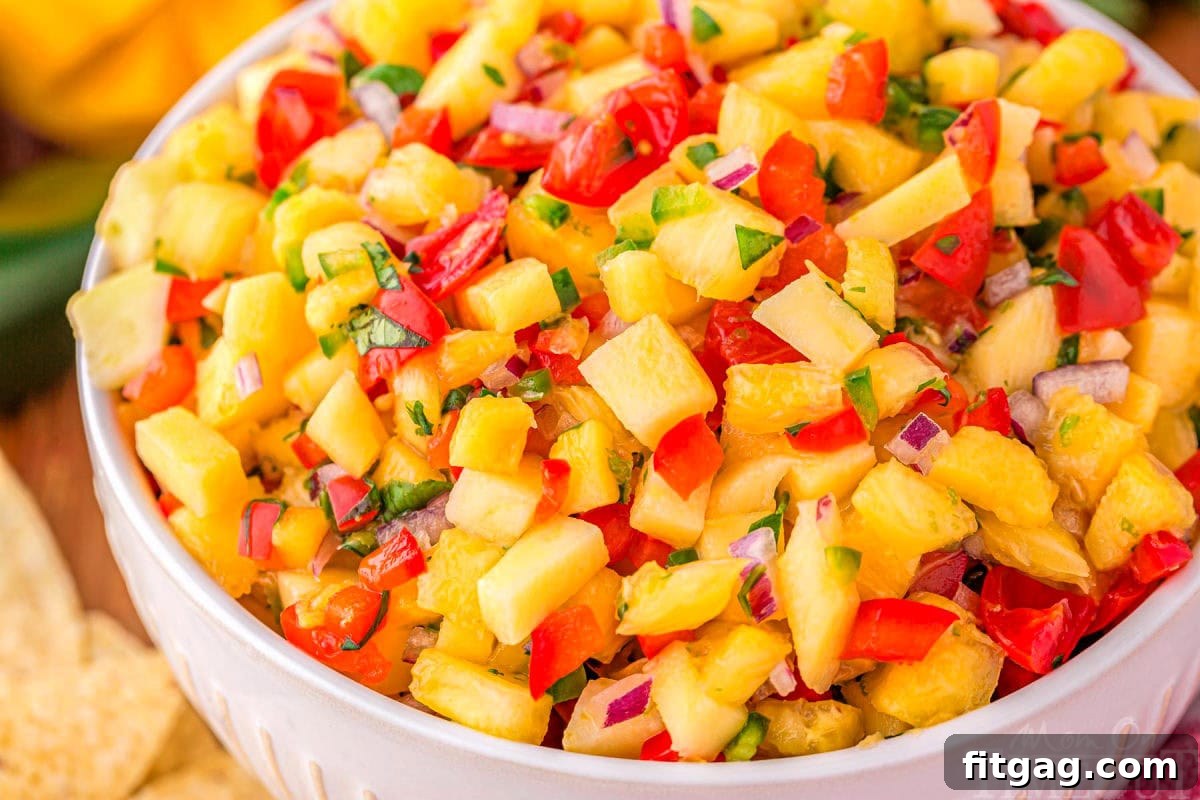 Tropical Pineapple Mango Salsa 5 close up of tropical pineapple salsa in a white serving bowl.