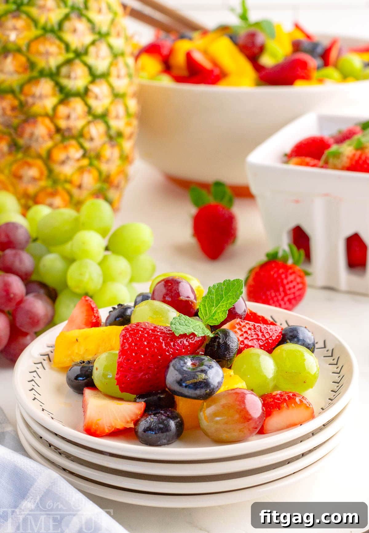 Sunshine Fruit Medley 4 A perfectly portioned serving of colorful fruit salad on a pristine white plate, with a background of various fresh fruits.