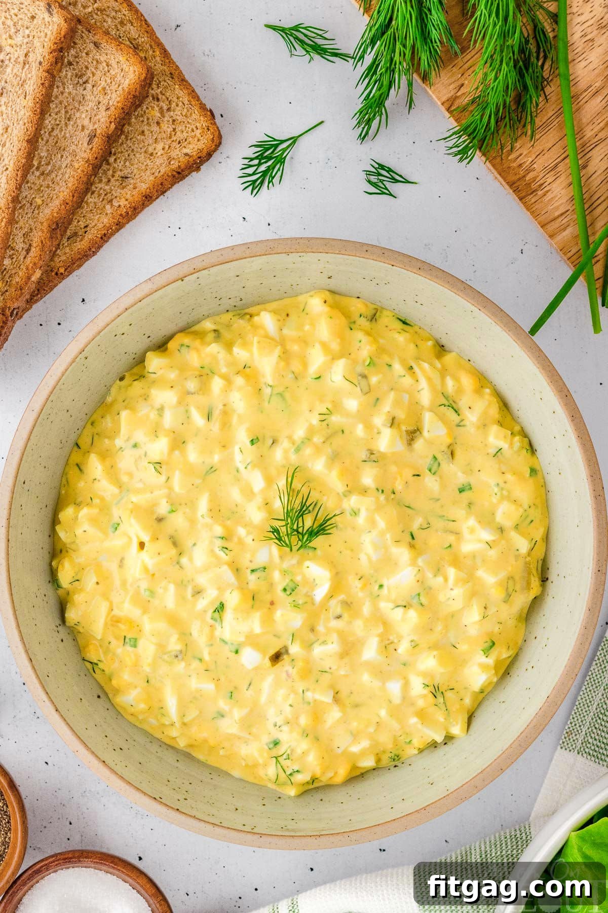 Savory Egg Salad Sensation 3 A pristine white bowl filled with creamy, vibrant egg salad, ready to be served.