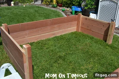 A large, empty raised garden bed with three sides built, viewed from inside.
