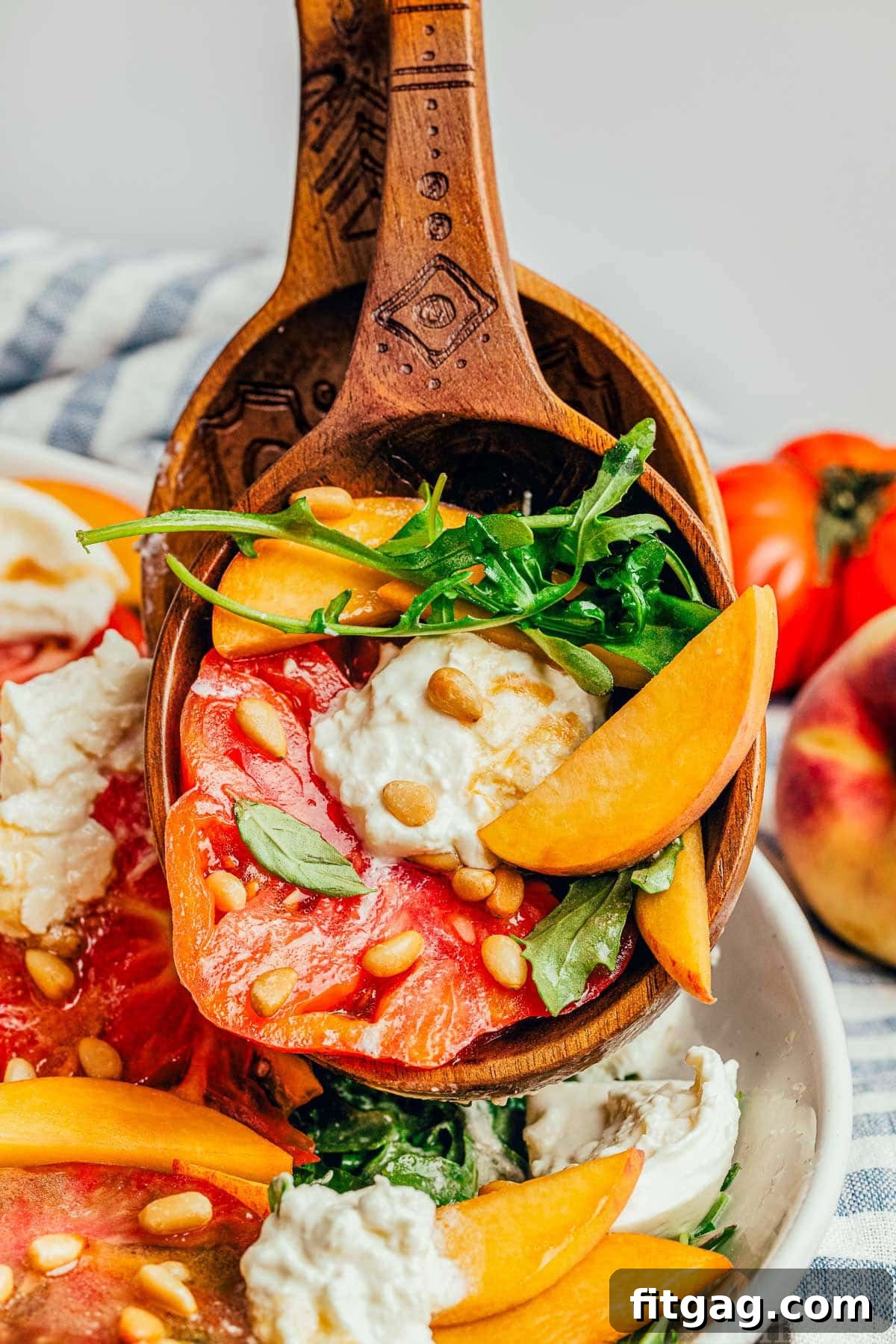 A scoop of peach salad recipe in salad tongs, highlighting all the main ingredients beautifully mixed.