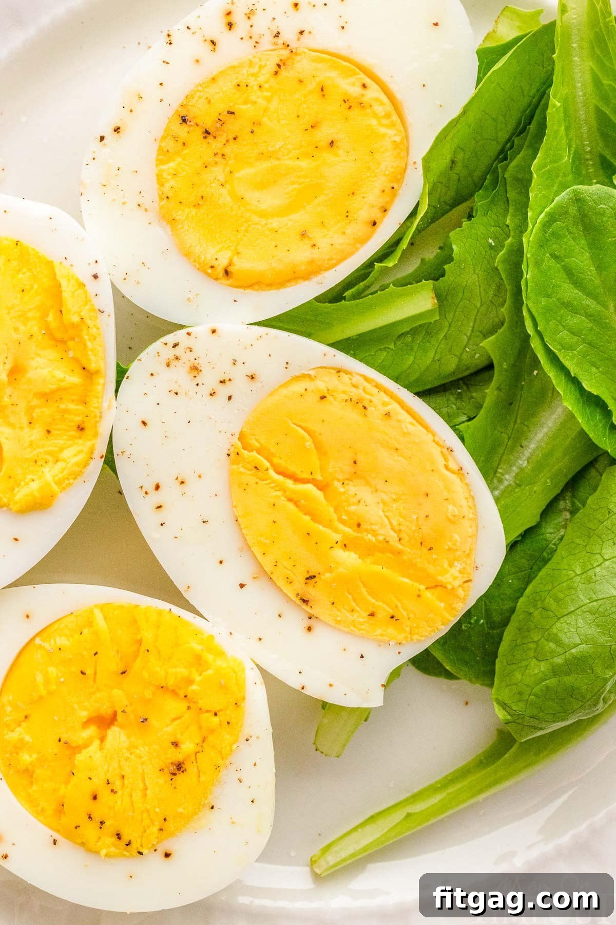 Hard boiled eggs on top of spinach leaves.