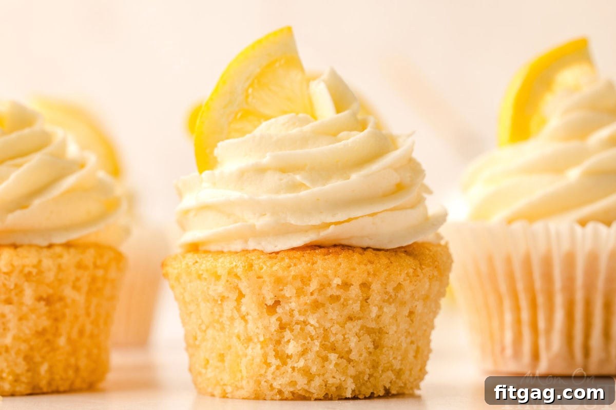 Side view of three perfectly frosted lemon cupcakes, showcasing their delicate texture and beautiful presentation.