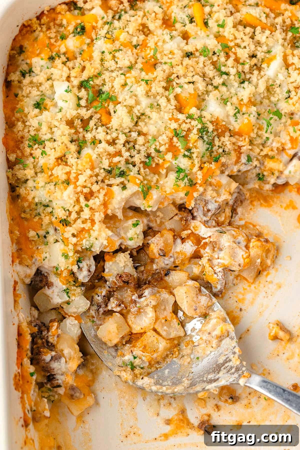 Hearty Beef Bake 3 Close up view of the ground beef casserole in a baking dish, with a portion already served.